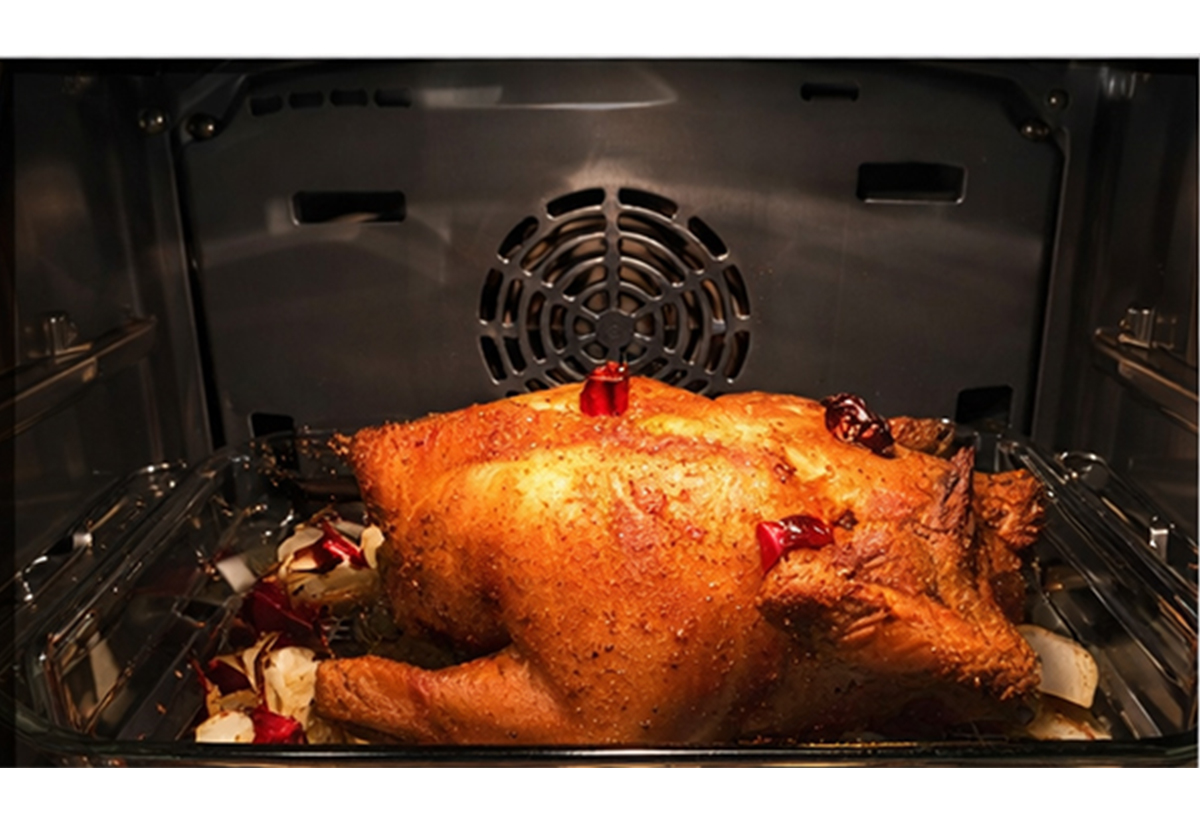 Απεικονίζεται κοτόπουλο να ψήνεται μέσα στον φούρνο.